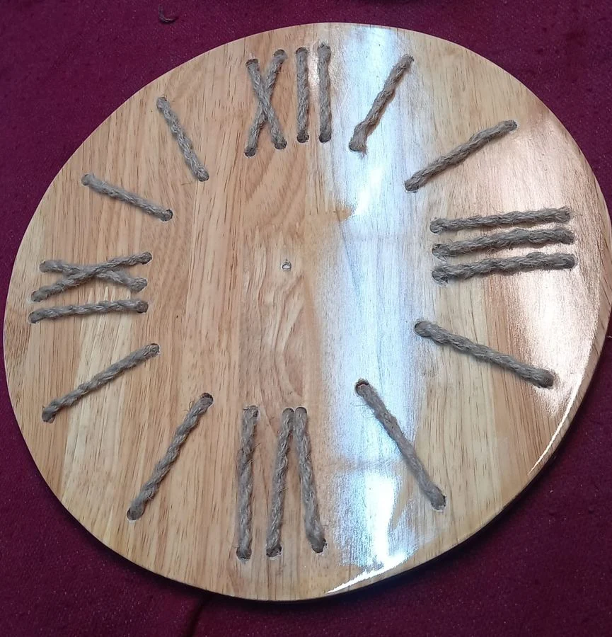 Wall clock with hand-cut Roman numerals on a wood face