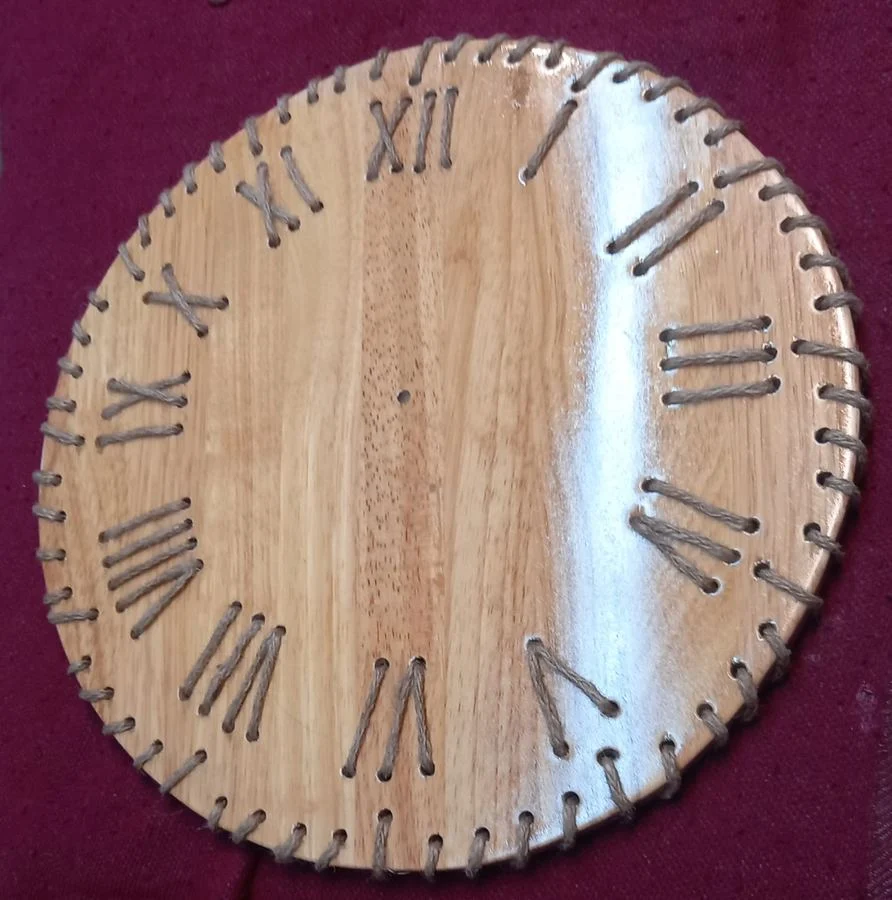 Round wall clock with Roman numerals cut into the rim