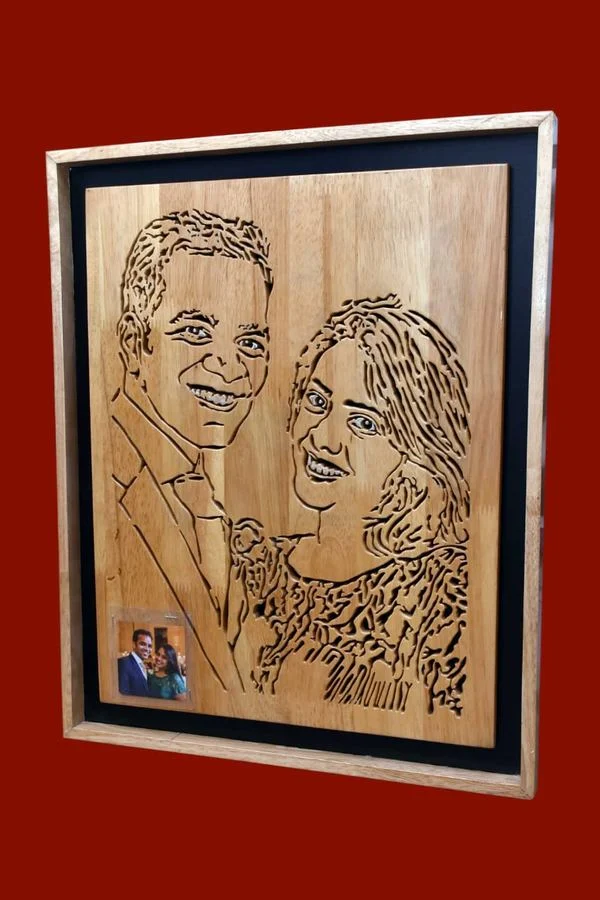 Portrait of a couple hand-cut in wood, framed on a red ground