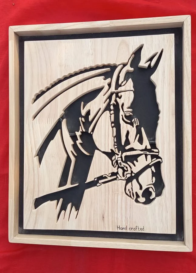 Bridled horse hand-cut in wood, framed on a red ground