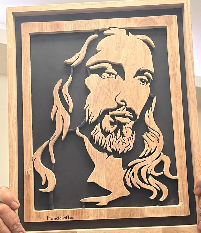 Portrait of Christ hand-cut in wood over a black backing