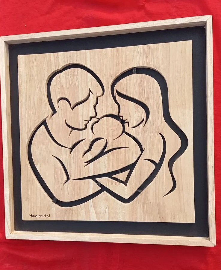 Mother and child rendered as a single continuous line in cut wood
