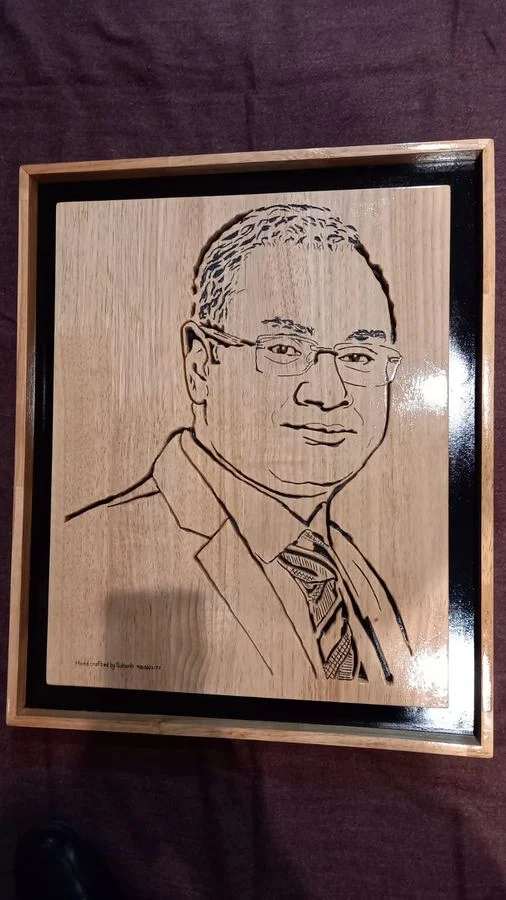 Framed portrait of a man in a suit, hand-cut in wood