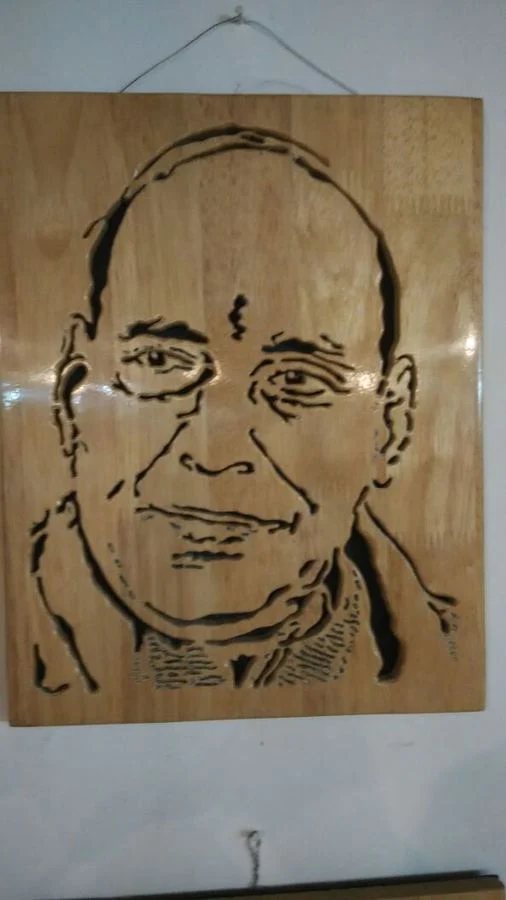 Portrait of a man hand-cut in wood on a pale panel
