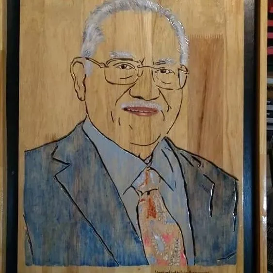 Hand-painted wood portrait of a seated gentleman