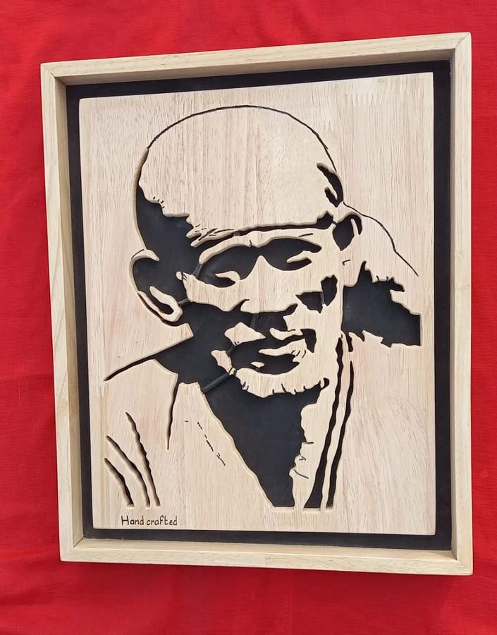 Sai Baba portrait in a light wood frame on a red ground