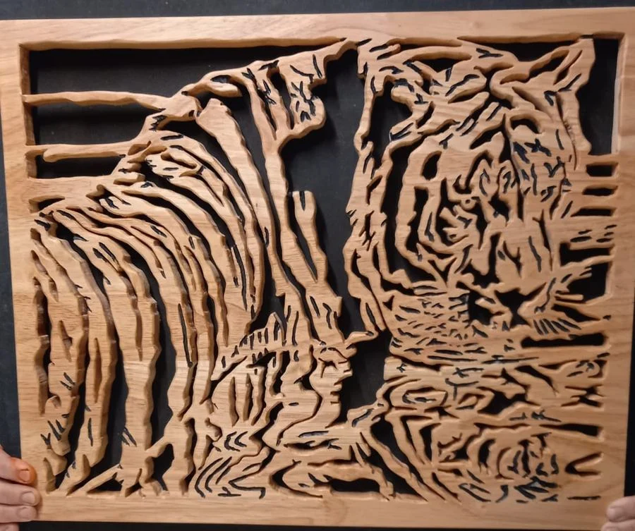Tiger panel held up to show the depth of the hand-cut relief