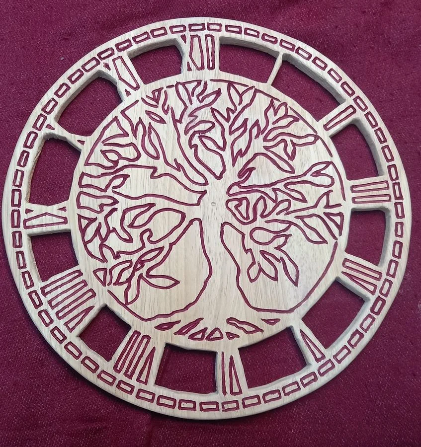 Circular wall clock with a Tree of Life cut into the face