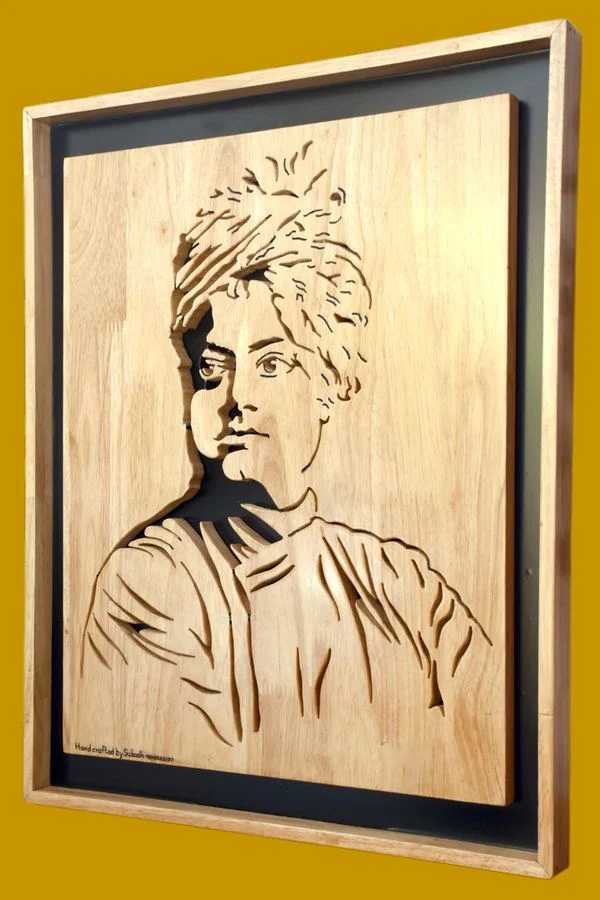 Swami Vivekananda portrait hand-cut in wood, shown at an angle